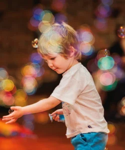 A young boy playing with bubbles