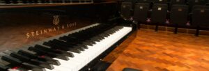 the keyboard of a grand piano in a concert hall