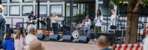 An audience watching a group of young people perform on an outdoor stage