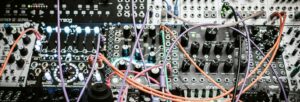A photo of a circuit board with many wires coming out of it.
