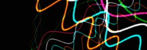 An abstract image of wiggles of brightly coloured light against a black background