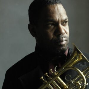A Black man in a dark blue shirt holding a trumpet