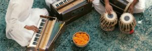 Instruments on a blue floor with orange flowers in a bowl.