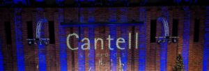 The words 'Cantell School' projected onto a brick wall lit with blue stage lights